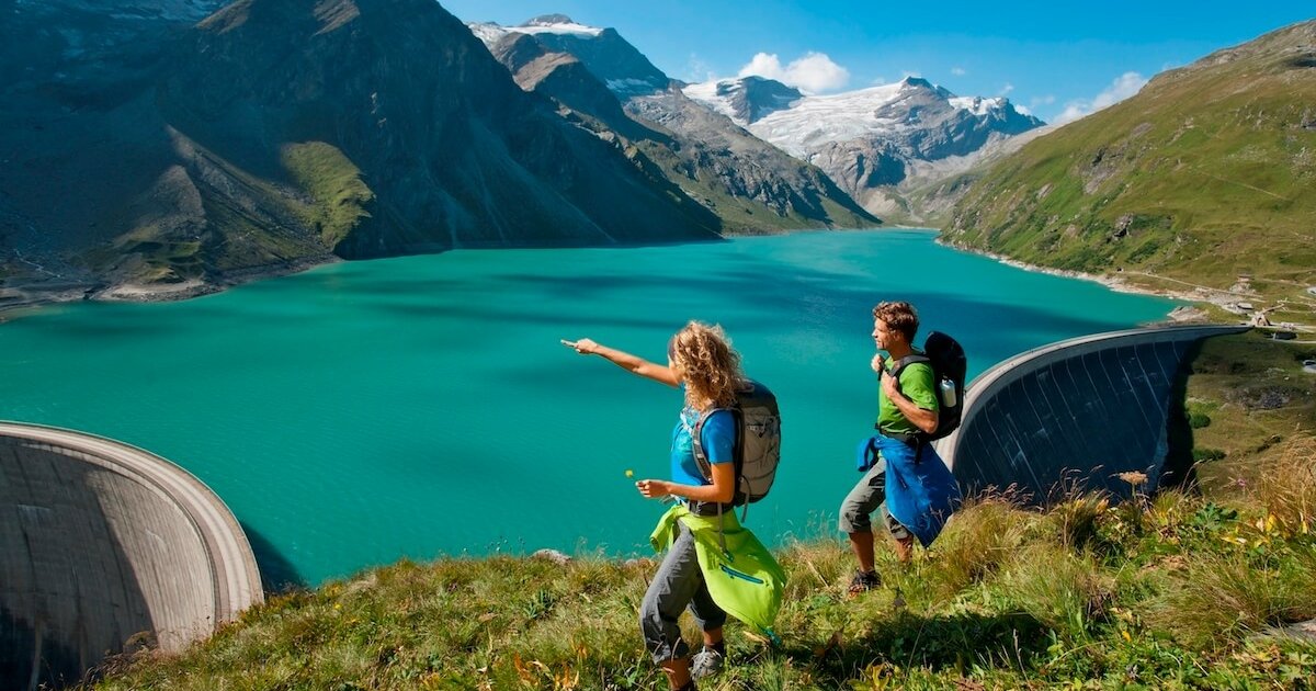 Zwei Wanderer an einem Stausee in den Bergen