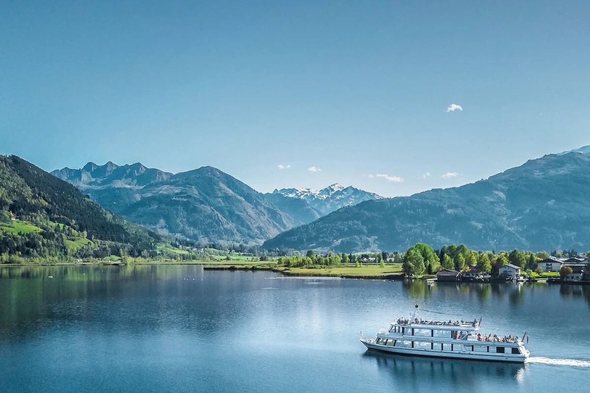 Ein weißes Schiff auf einem See mit Bergen im Hintergrund