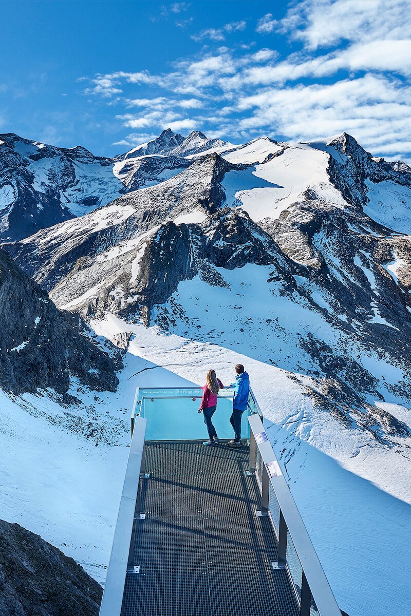 Zwei Urlauber auf einer Aussichtsplattform mit Sicht auf den Gletscher nahe des Wellnesshotels Kaprun