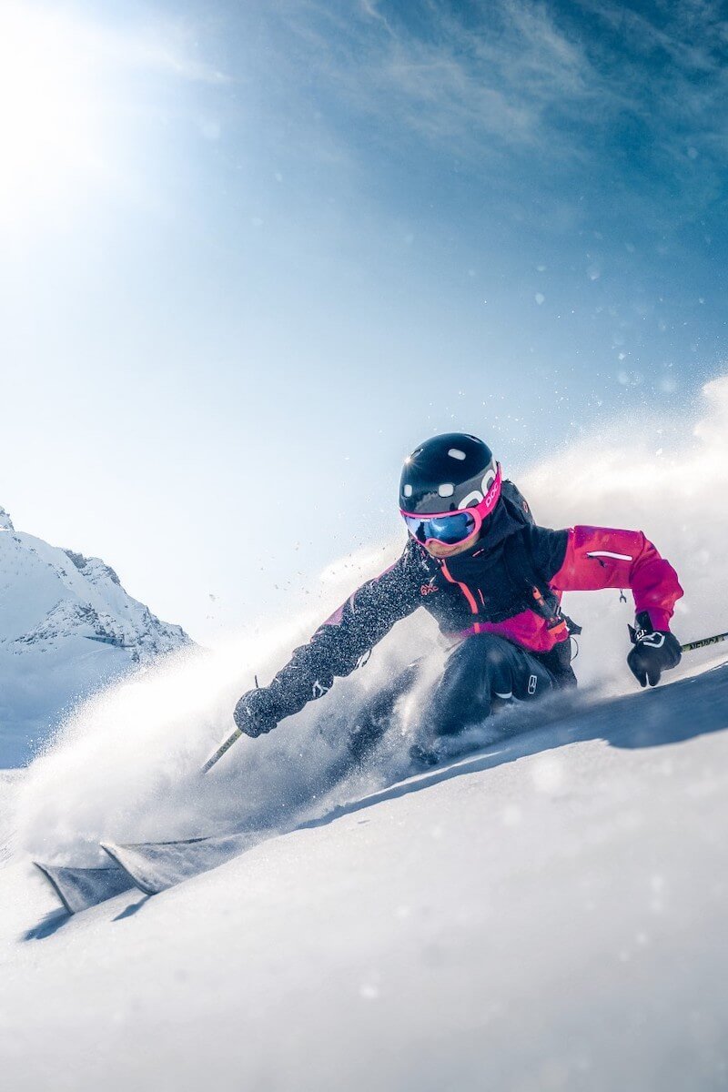 Junges Mädchen das in den Bergen Ski fährt