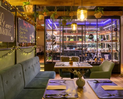 Gemütlich eingerichtetes Restaurant mit vielen Hängepflanzen