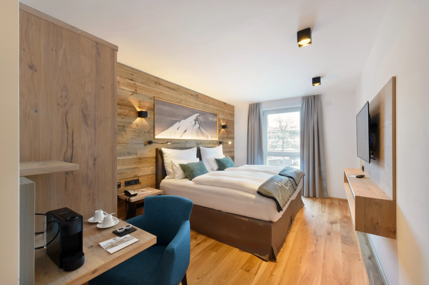 Modernes Hotelzimmer mit Doppelbett, Holzdesign und warmem Licht